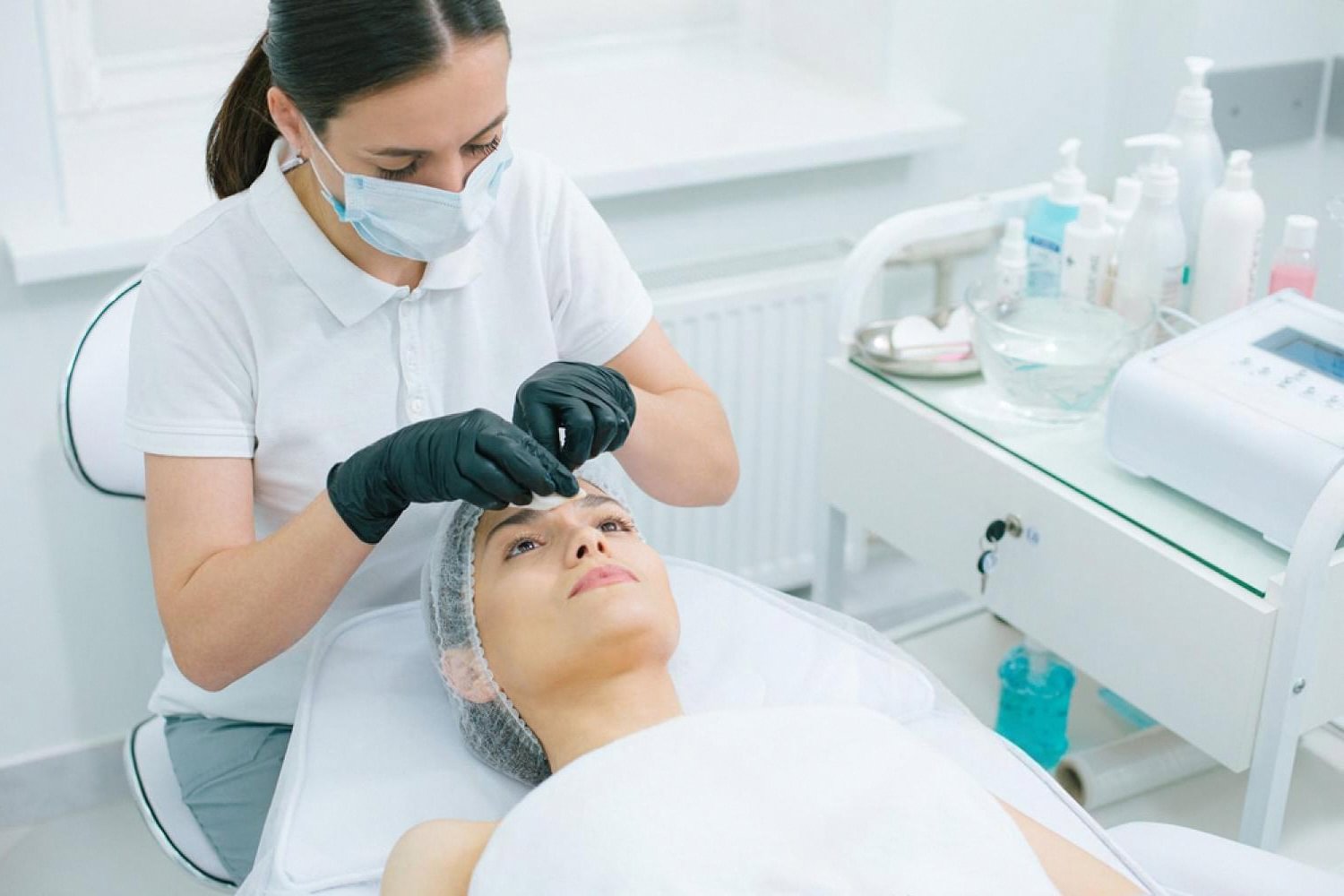 Dermatologist examining a patient's forehead skin during a preventive check-up in the UAE