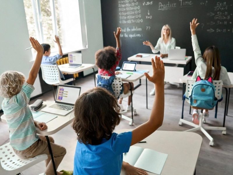 Primary school students raising hands during a maths lesson in a UAE classroom