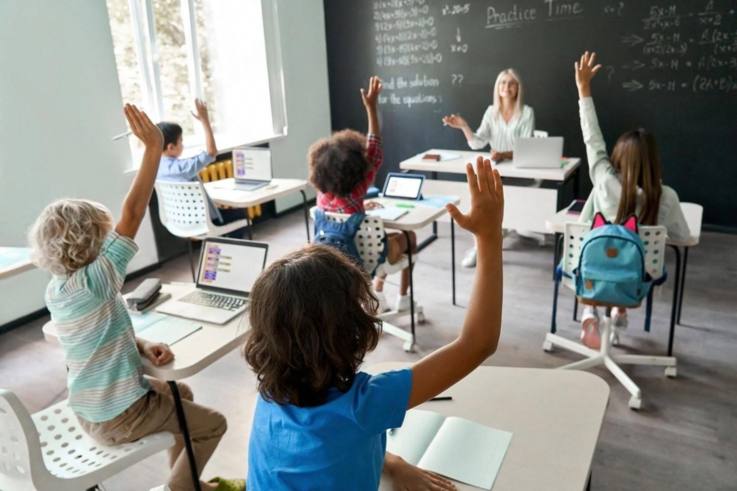 Primary school students raising hands during a maths lesson in a UAE classroom
